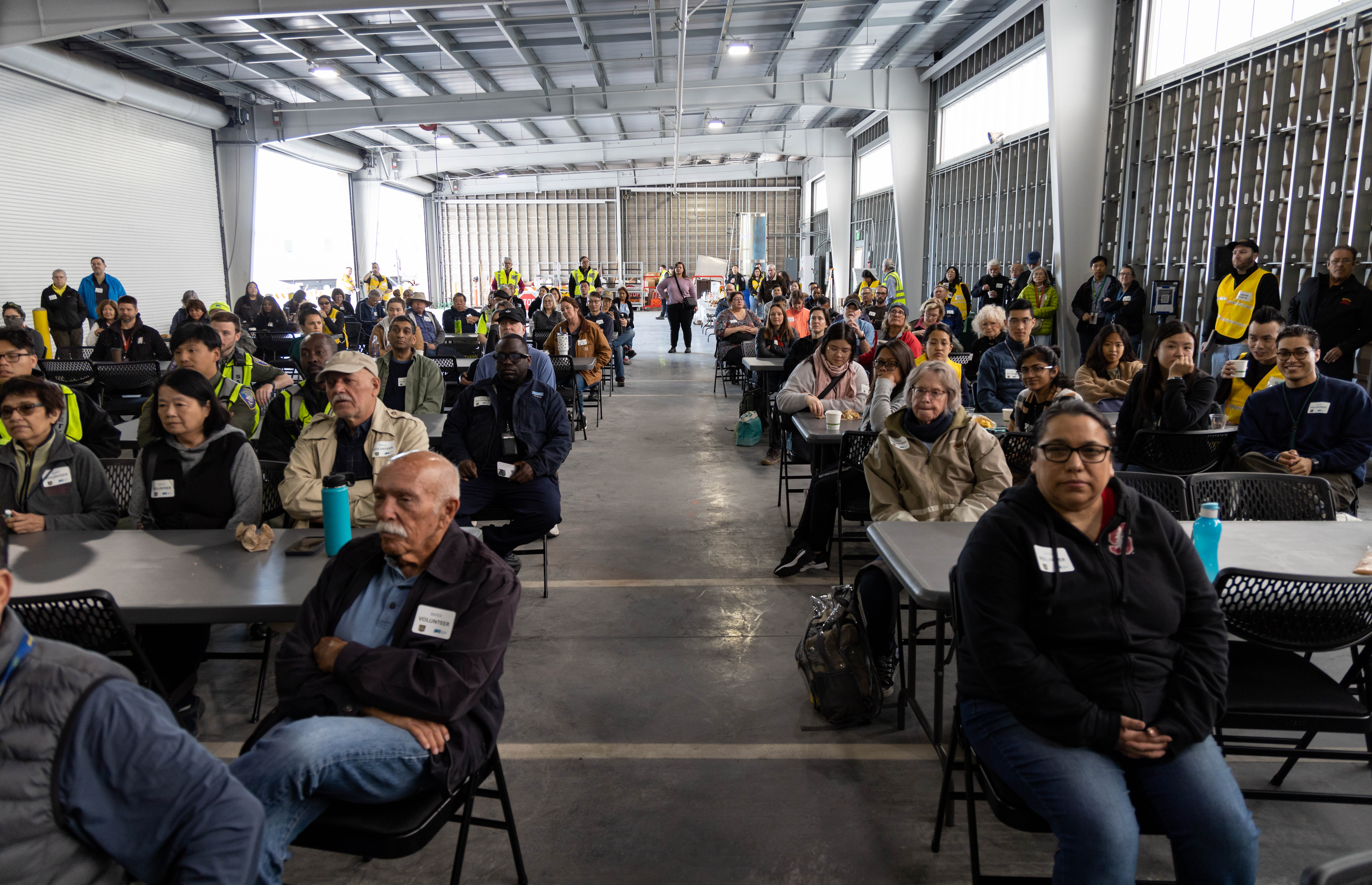 People sitting on chairs in a large room.