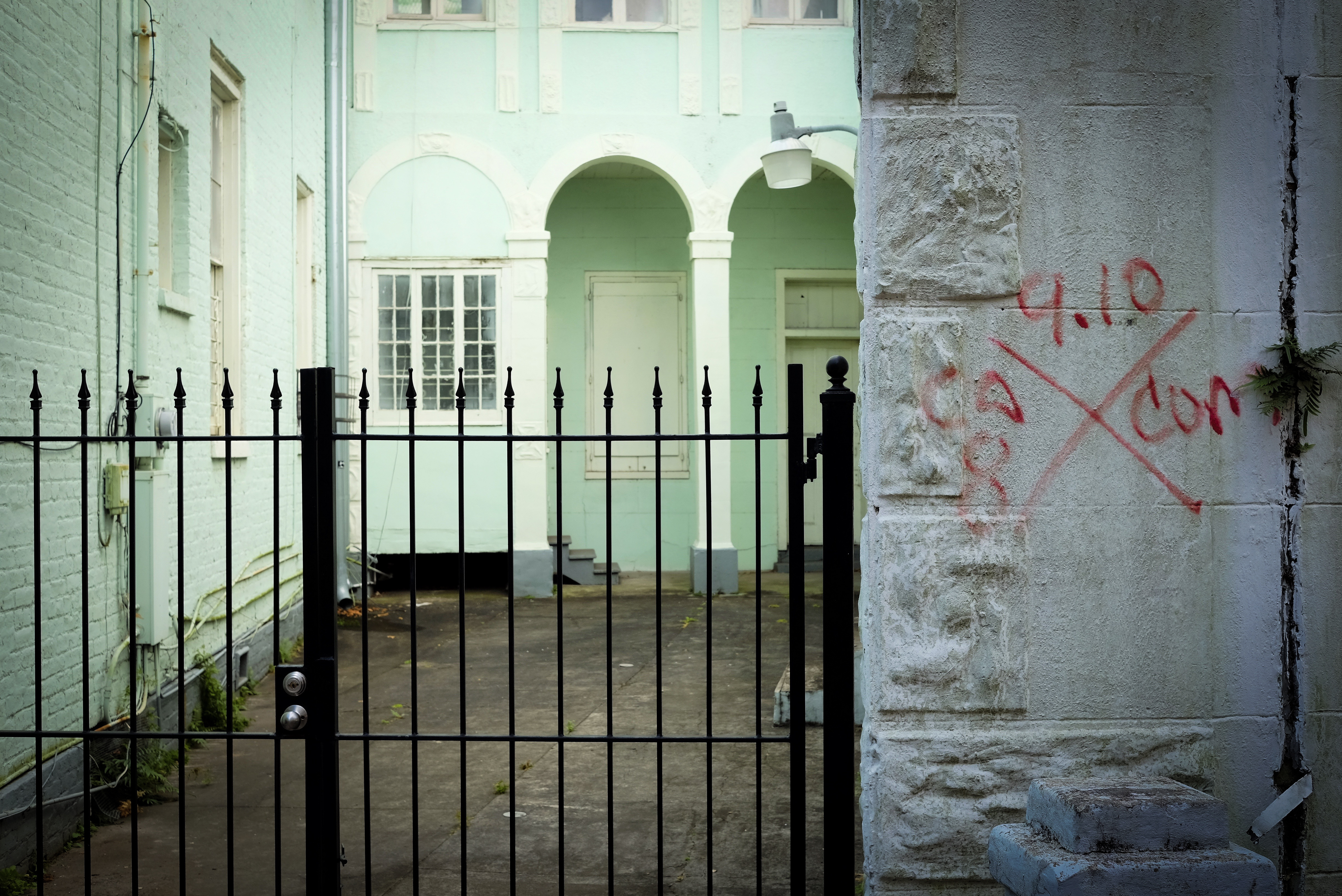 A photograph of a building in New Orleans, with a search and rescue making spray painted onto the stone wall.