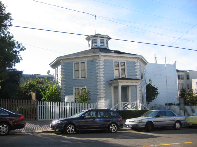 A photo of a house in San Francisco with eight sides; an octagon house. It is painted blue with white accents on the building trim.