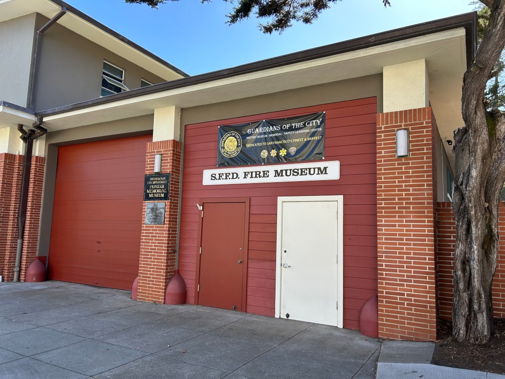 A picture of a brick building, and two doors, with a sign saying S F F D Museum.