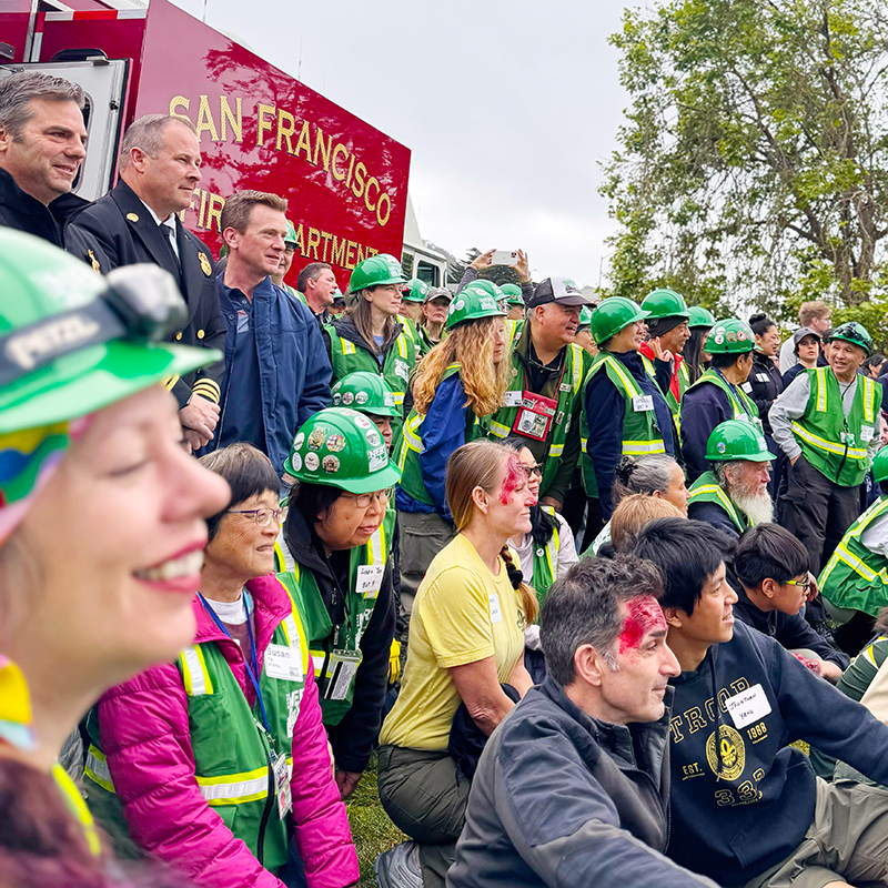 Dozens of drill participants pose for a picture; some volunteers have been injured to act as disaster survivors as a training exercise.