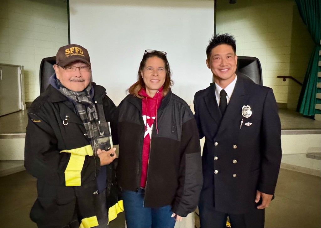 All with big smiles: Commissioner Stephen Nakajo, Deputy Chief Erica Brown, and Captain Brandon Tom pose for a picture with Commissioner Nakajo holding the Community Excellence Award.