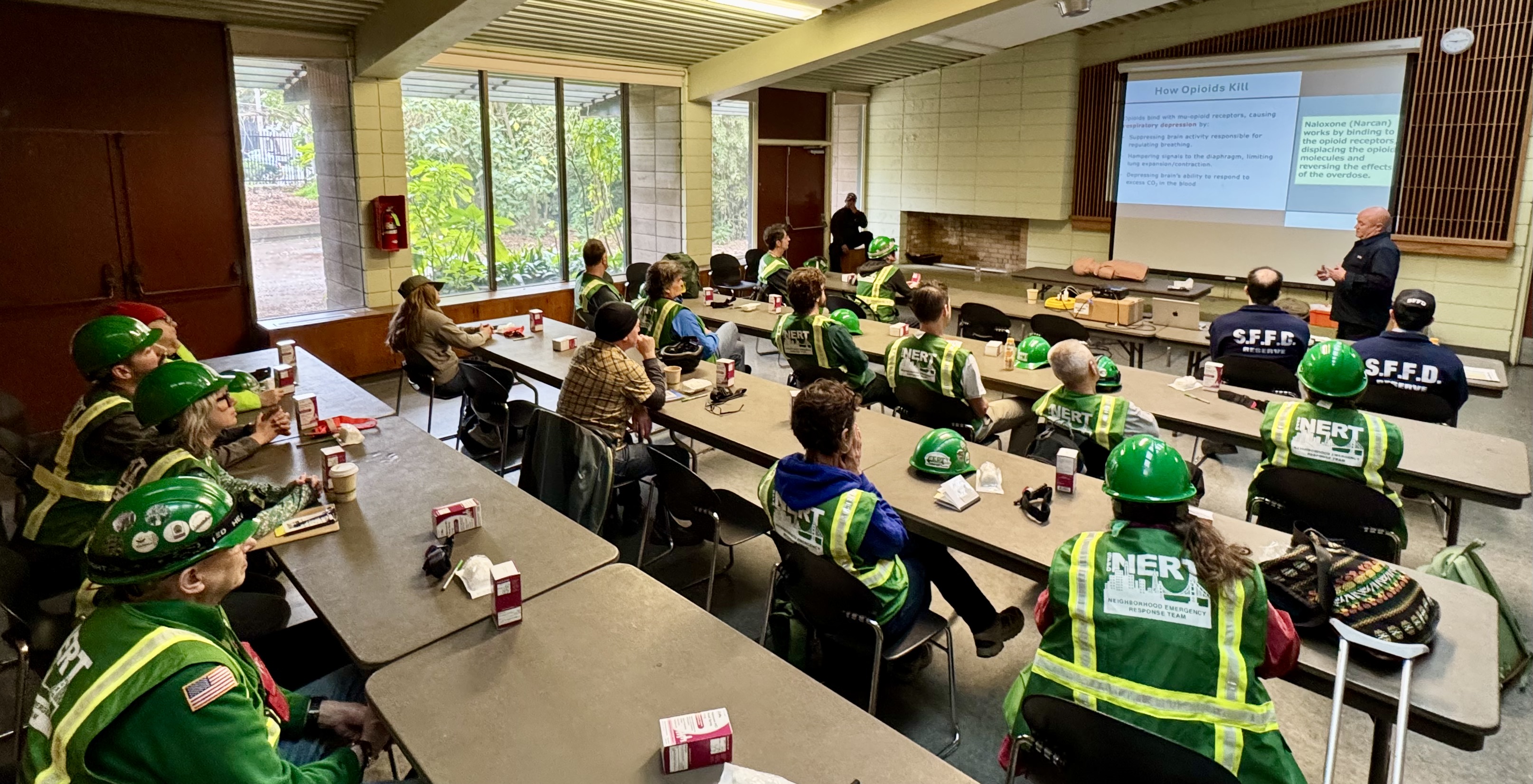N E R Ts in a classroom, listening to a presentation about administering Narcan.